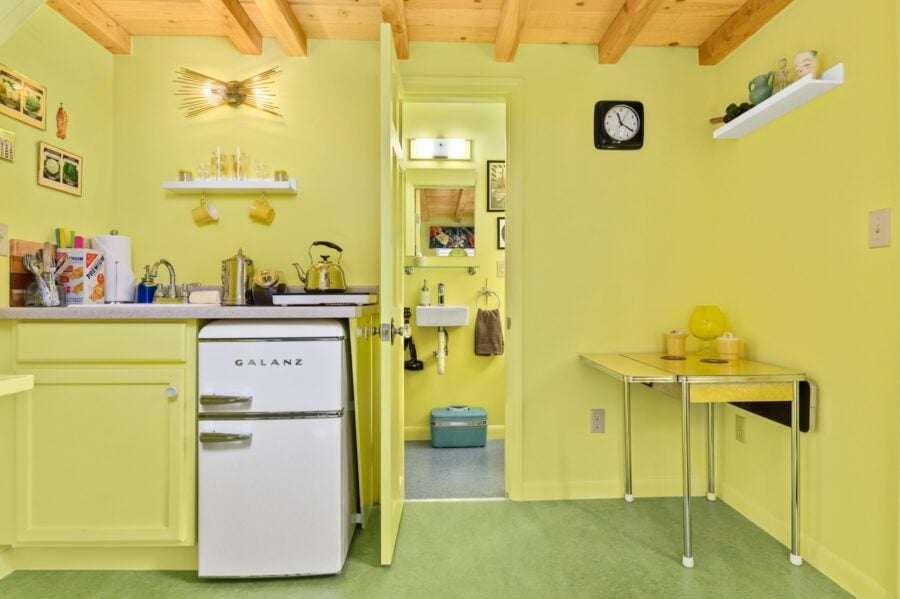 Retro fridge, drop leaf table, and bathroom door in the Rock n Roll tiny house