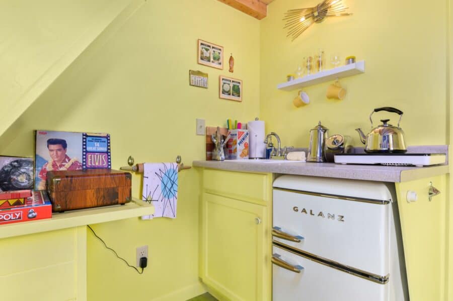 Kitchenette with retro fridge and vintage memorabilia in the Rock n Roll tiny house