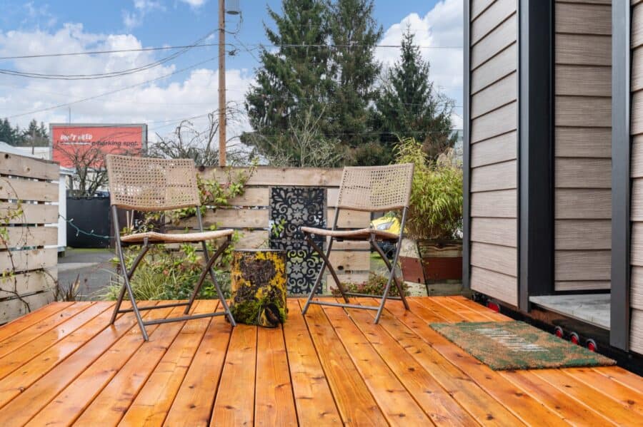 Large cedar deck with two chairs outside the Zen tiny house at Tiny Digs
