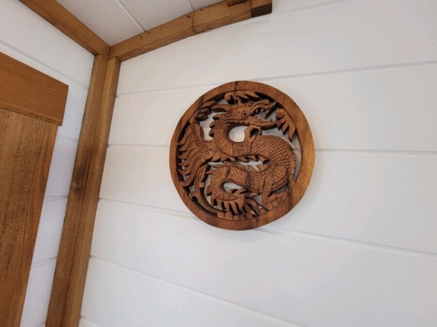 Carved wooden dragon medallion on the wall of the Zen tiny house