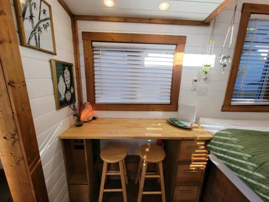 Wood desk with two stools under a window in the Zen tiny house