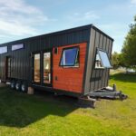 Tiny House with modern design and large windows by the lake.