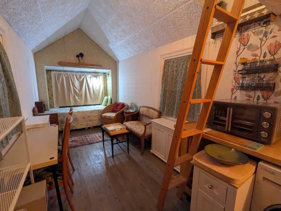 Charming tiny house living space with compact furniture and a loft area in Upstate New York.