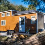 Charming tiny house on wheels featuring vibrant exterior and seaside-inspired surroundings in Melbou.