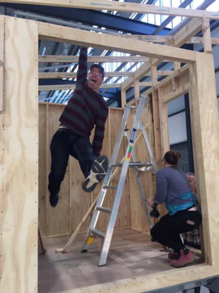 Two people building a tiny house frame during Vermont summer camp.