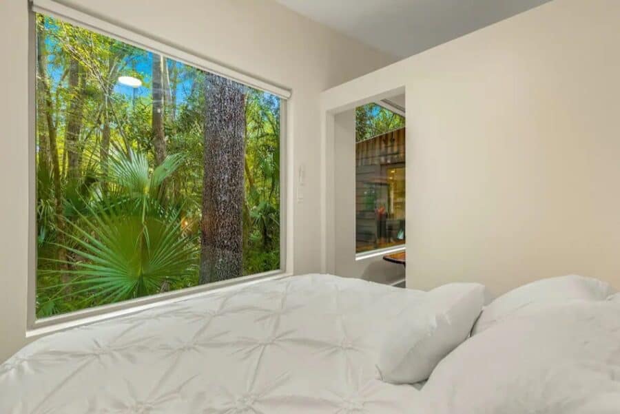 Bright interior with large windows overlooking lush forest.