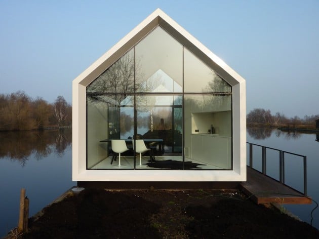 Perfectly symmetrical front view in winter showing glass gable reflecting the interior furnishings and calm lake