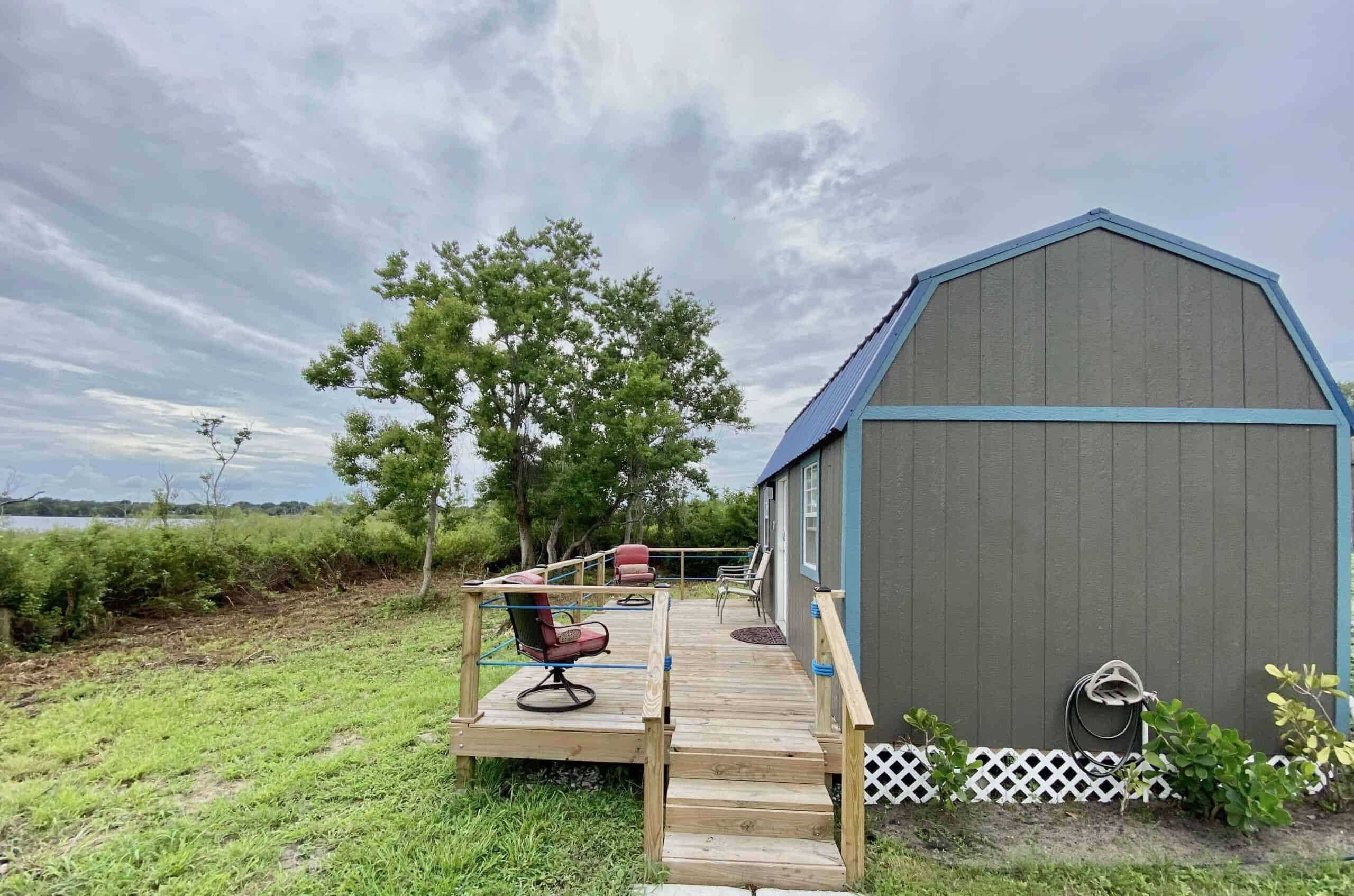 Modern tiny lake cottage with blue roof and deck on lakefront property in Winter Haven Florida near LEGOLAND