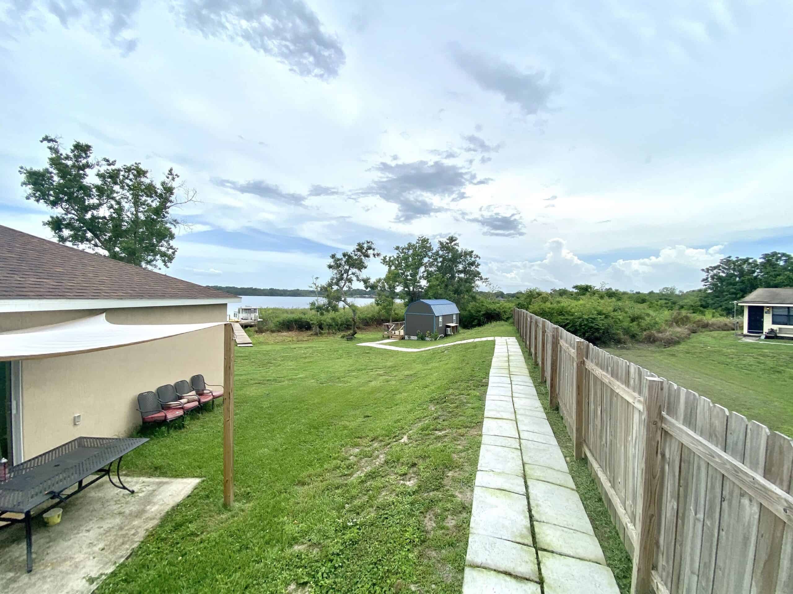 Wide view of the lakefront property showing the tiny cottage, main house, and Lake Mariam