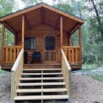 Charming tiny log cabin with front porch nestled in lush Florida woods. Perfect for small space livi.