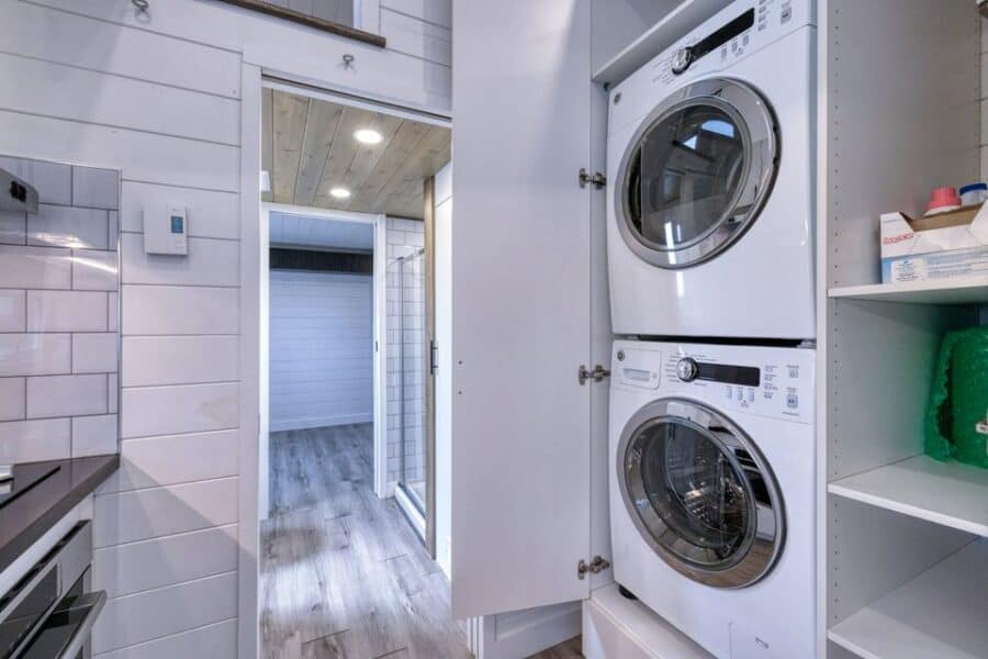 Compact laundry space with stacked washer and dryer in a tiny house.