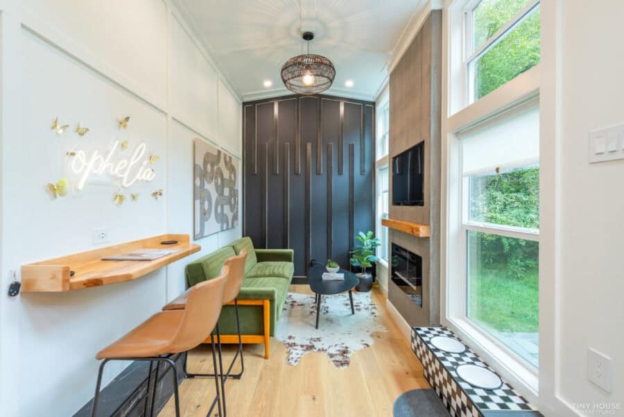 Cozy tiny house interior with modern decor and large windows.