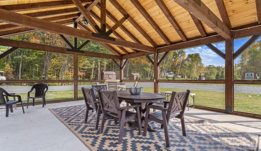 Outdoor tiny house porch with dining table and chairs, perfect for small space living and enjoying n.