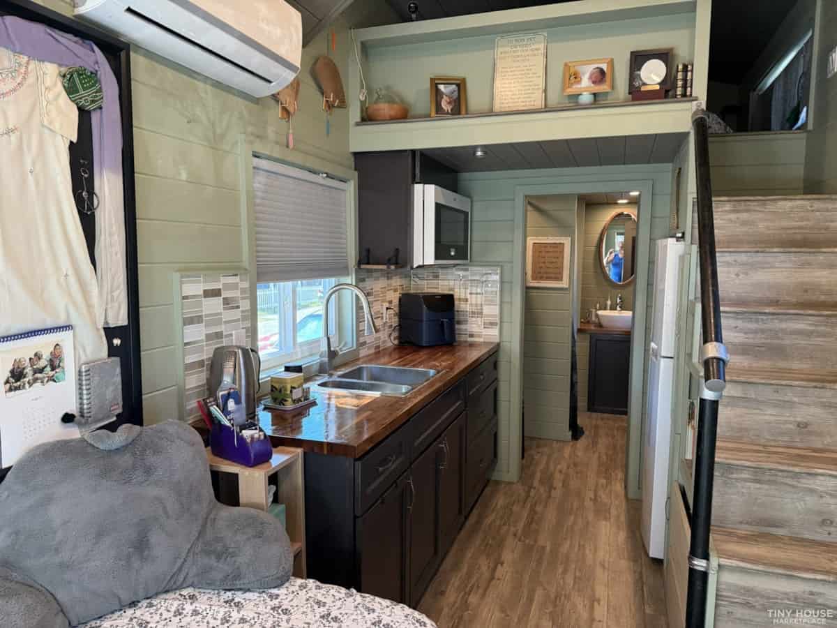 Compact tiny house kitchen with modern appliances and cozy living space.