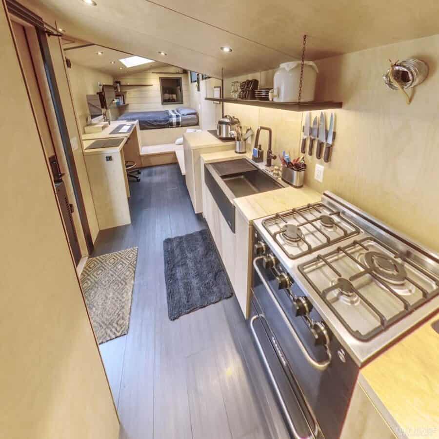 Compact tiny house kitchen with modern appliances and cozy living space.
