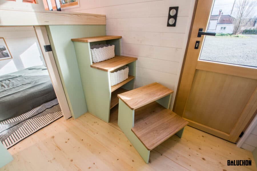 Interior view of a tiny house with a creative flex room loft and stairs.