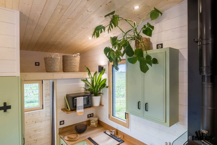 Bright tiny house interior with creative flex room loft and natural wood finishes.