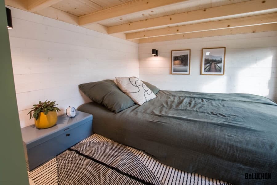 Compact tiny house bedroom with creative flex room loft for versatile living space.