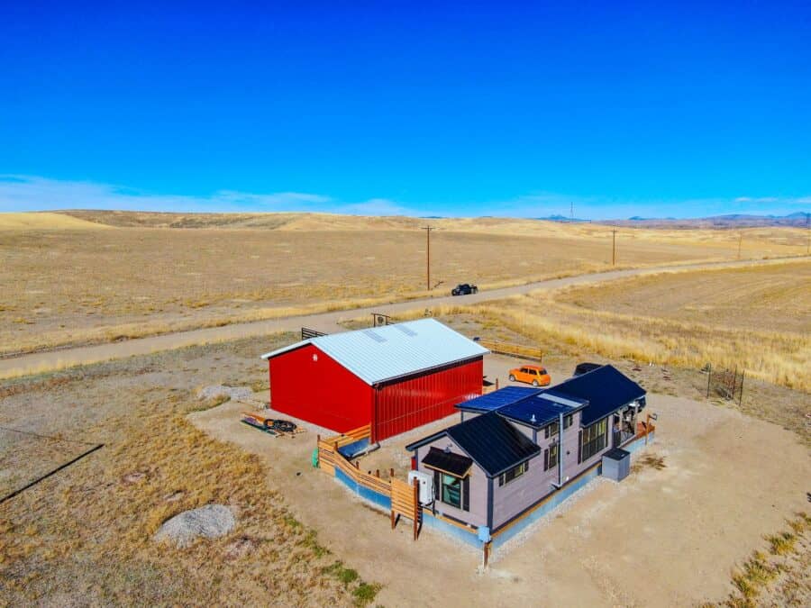 Small modern tiny house on expansive rural land with open skies.