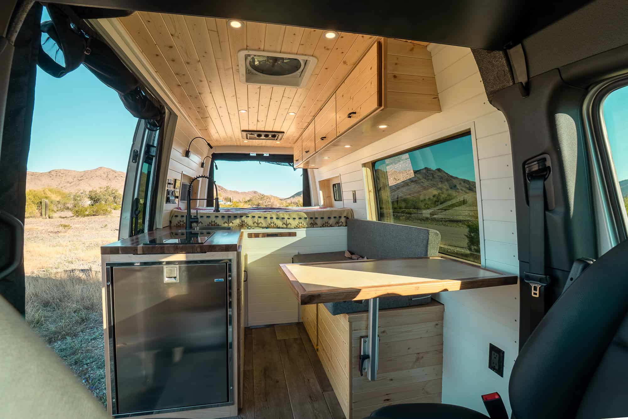 Bennett layout galley with induction cooktop, walnut butcher block counter and a black Isotherm 130 fridge