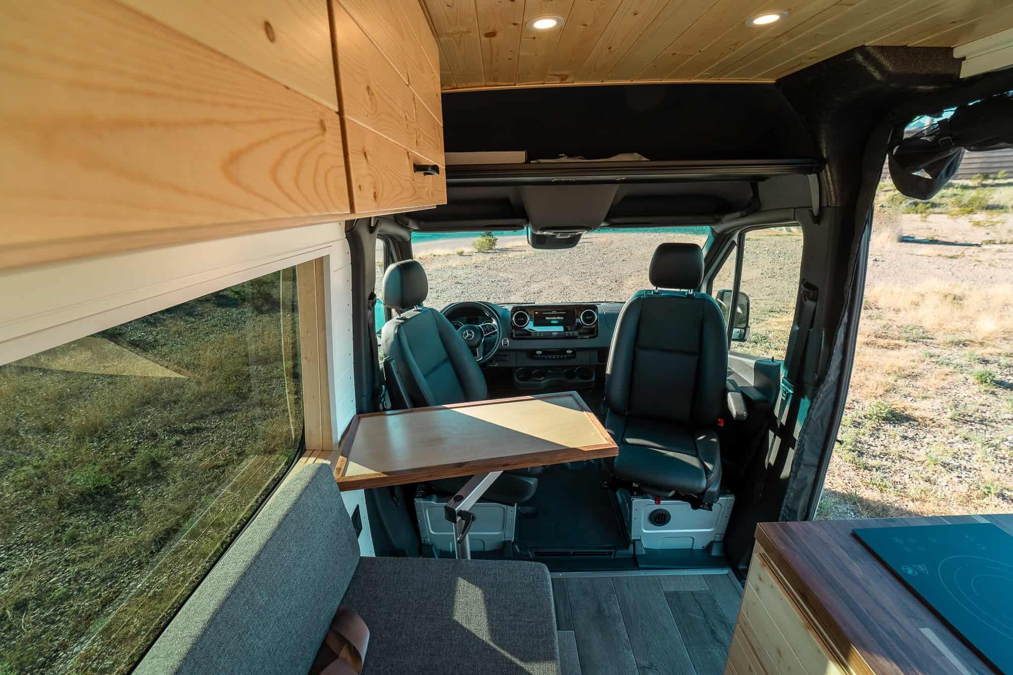 Both cab seats swiveled to face the dinette table inside the Tommy Camper Vans Sprinter