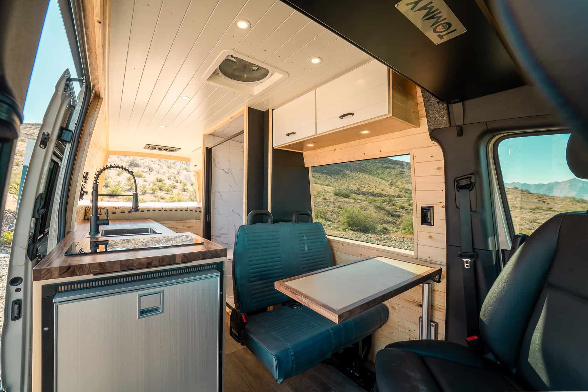 Interior of The MAV showing the marble-look wet bath enclosure, induction cooktop and belted bench seat