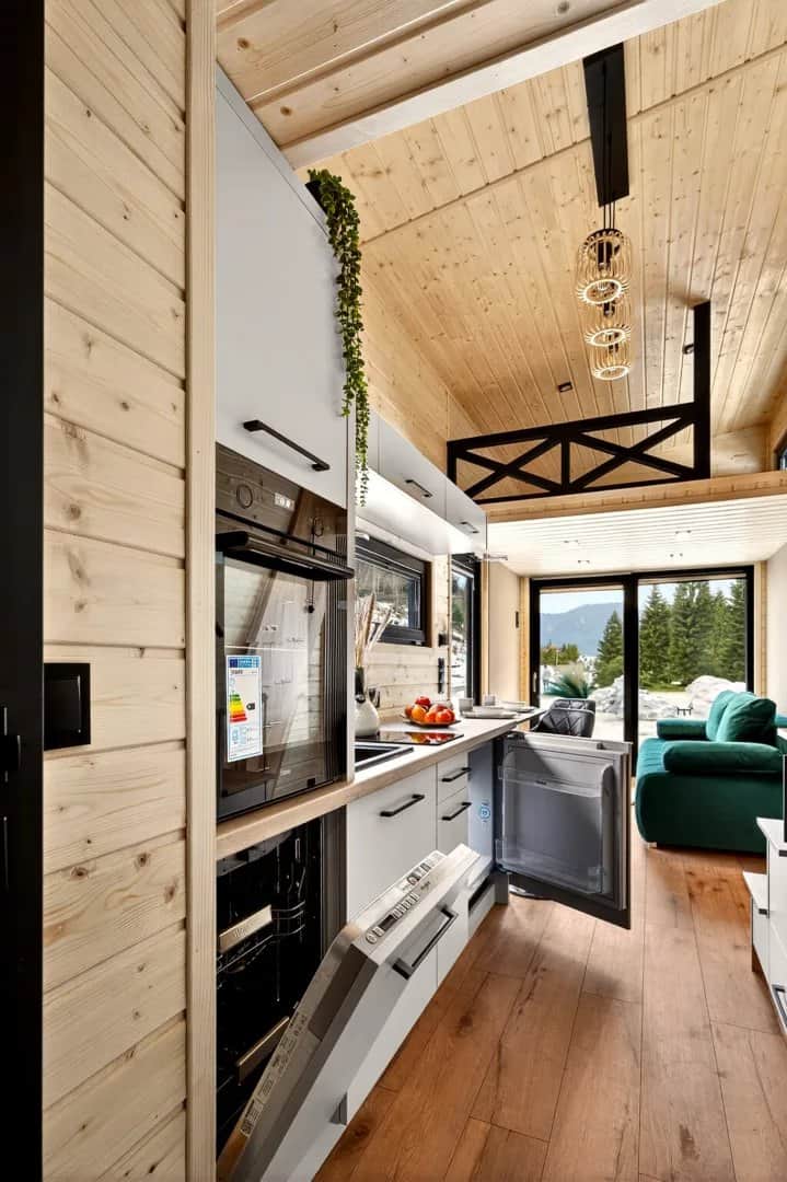 Built-in oven, refrigerator, and appliances in the Tommy tiny house kitchen