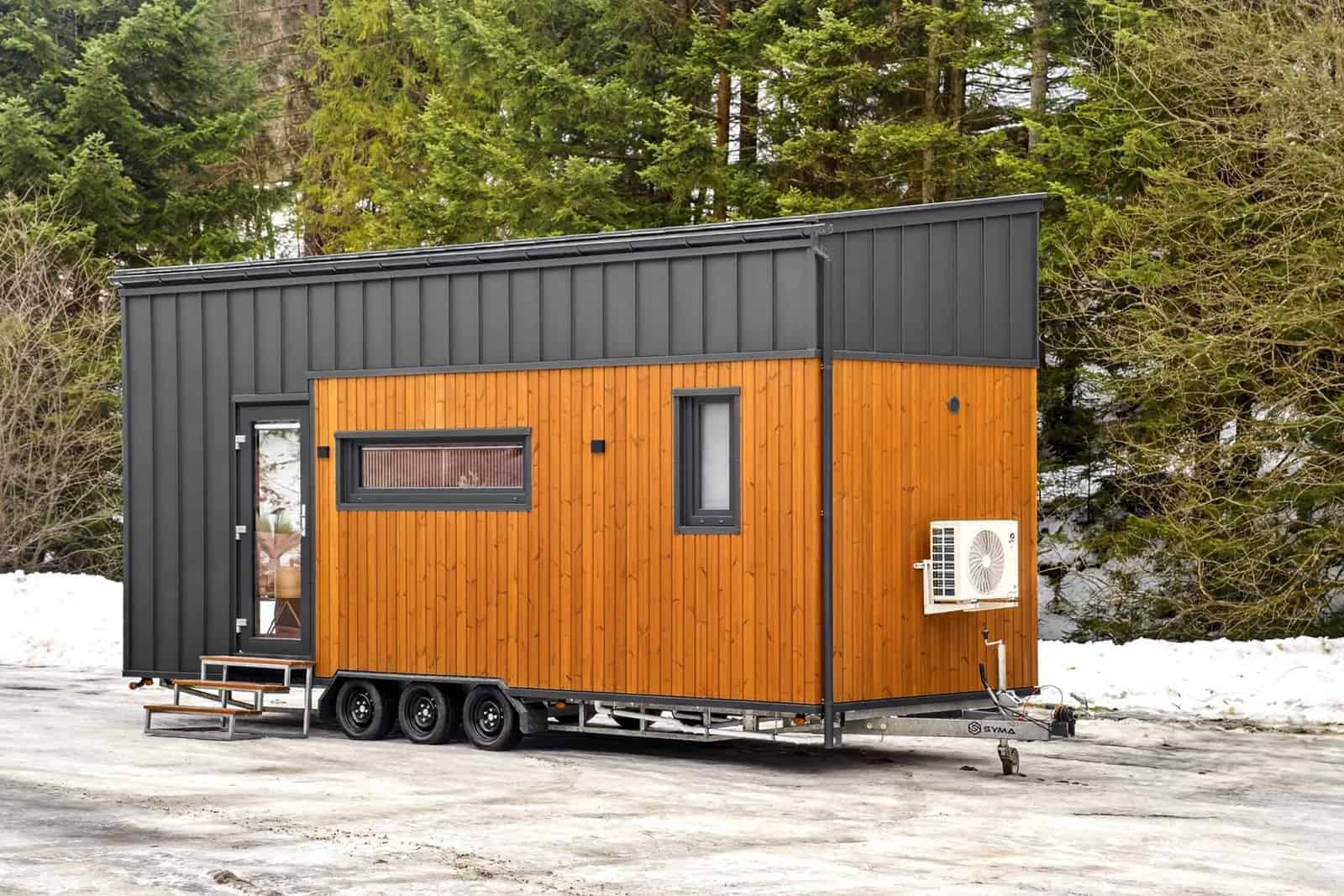 Rear exterior of the Tommy tiny house with thermo-pine cladding and an exterior air-conditioning unit