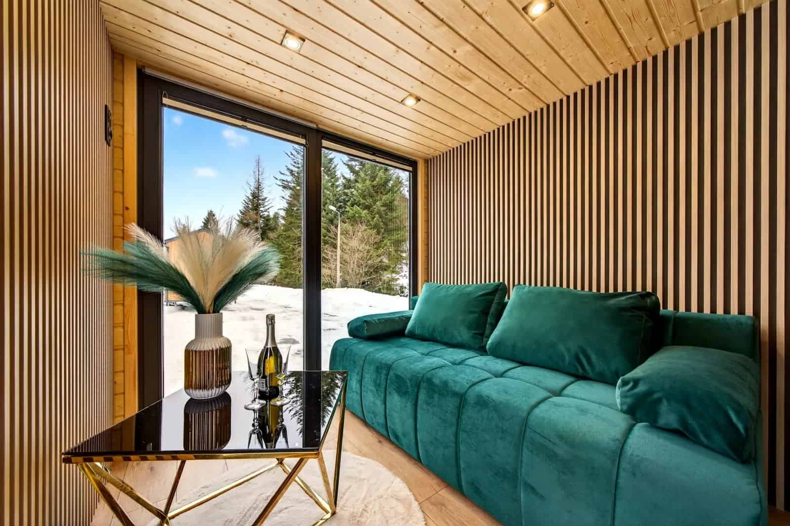 Slatted wood accent wall and green velvet sofa in the Tommy tiny house living room