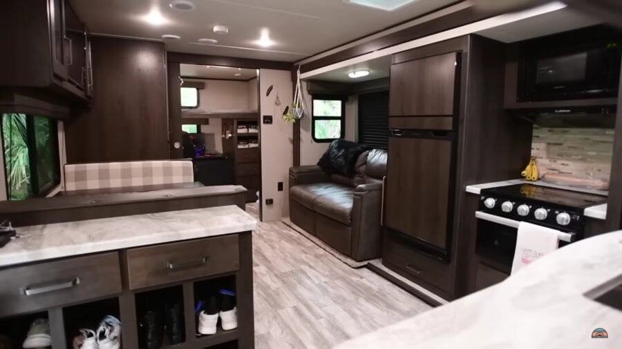 Modern tiny house interior with kitchen, sofa, and compact living space.