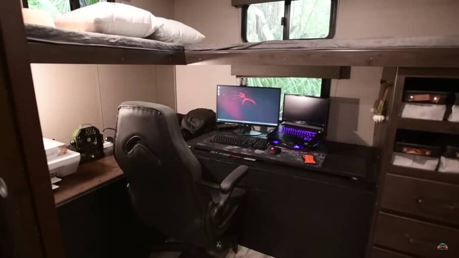 Compact tiny house workspace with desk and computer.
