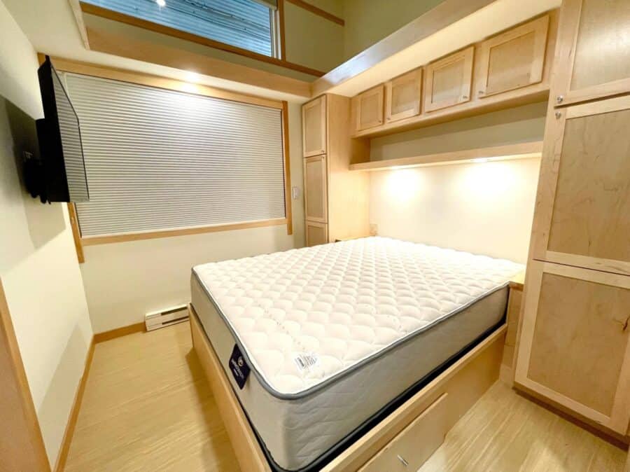 Escape Tiny House interior with a cozy bed and custom cabinetry.