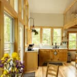 Cozy treehouse kitchen with large windows and natural wood finishes in Vermont.