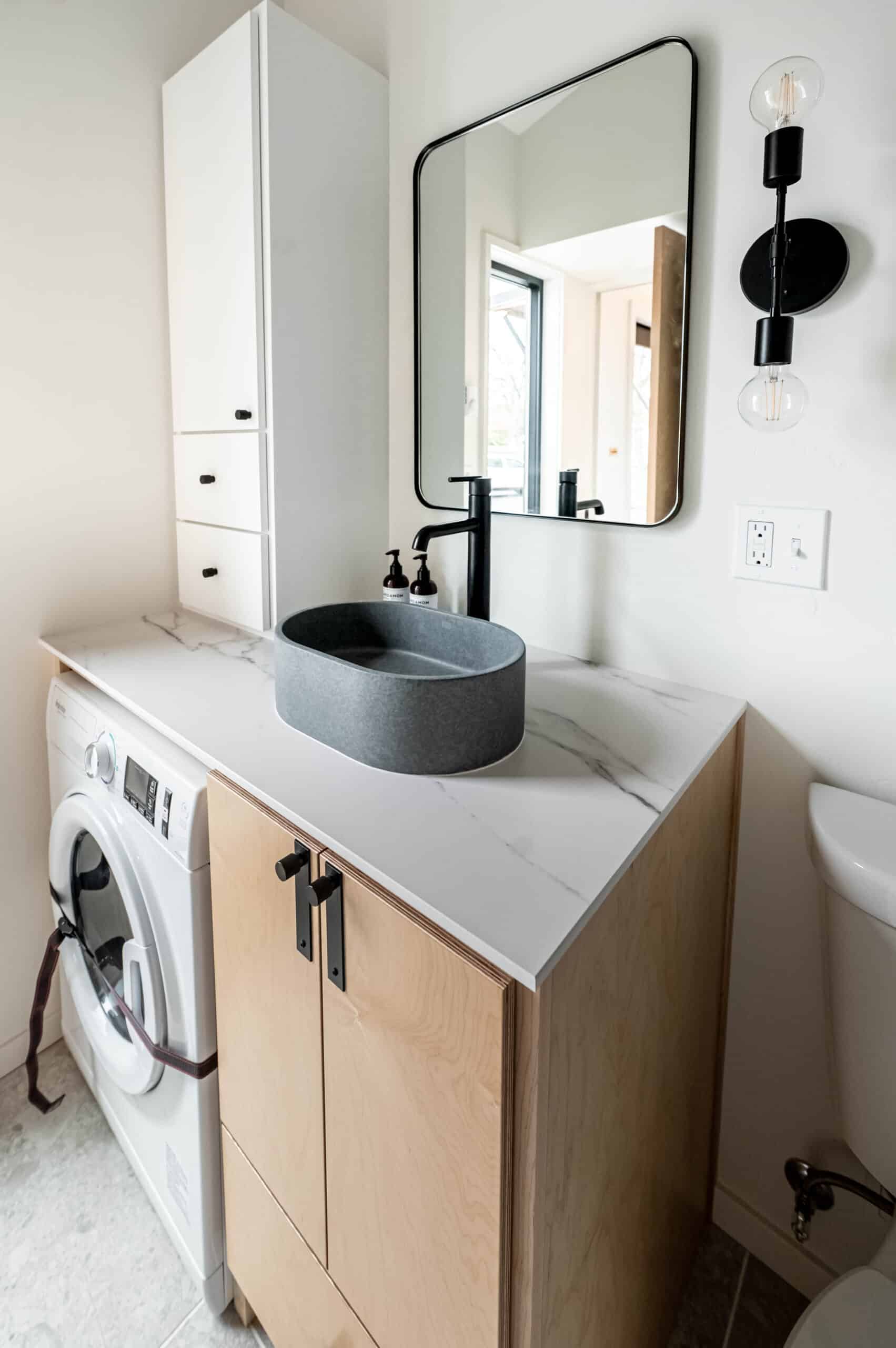 Custom vanity with concrete vessel sink and matte black fixtures in the Urban Gable bathroom