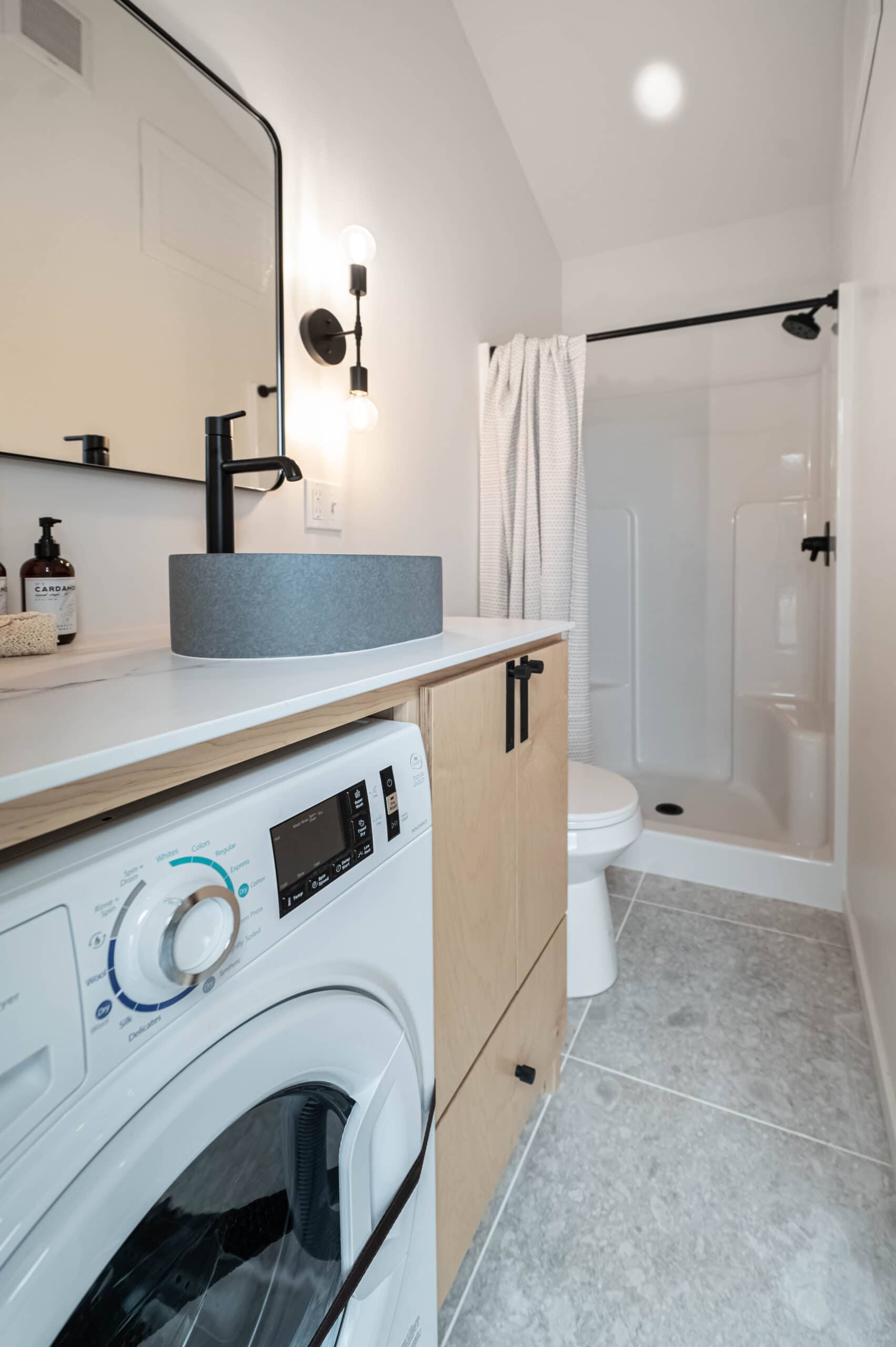 Bathroom with washer dryer combo, terrazzo tile, and fiberglass shower in the Urban Gable Park