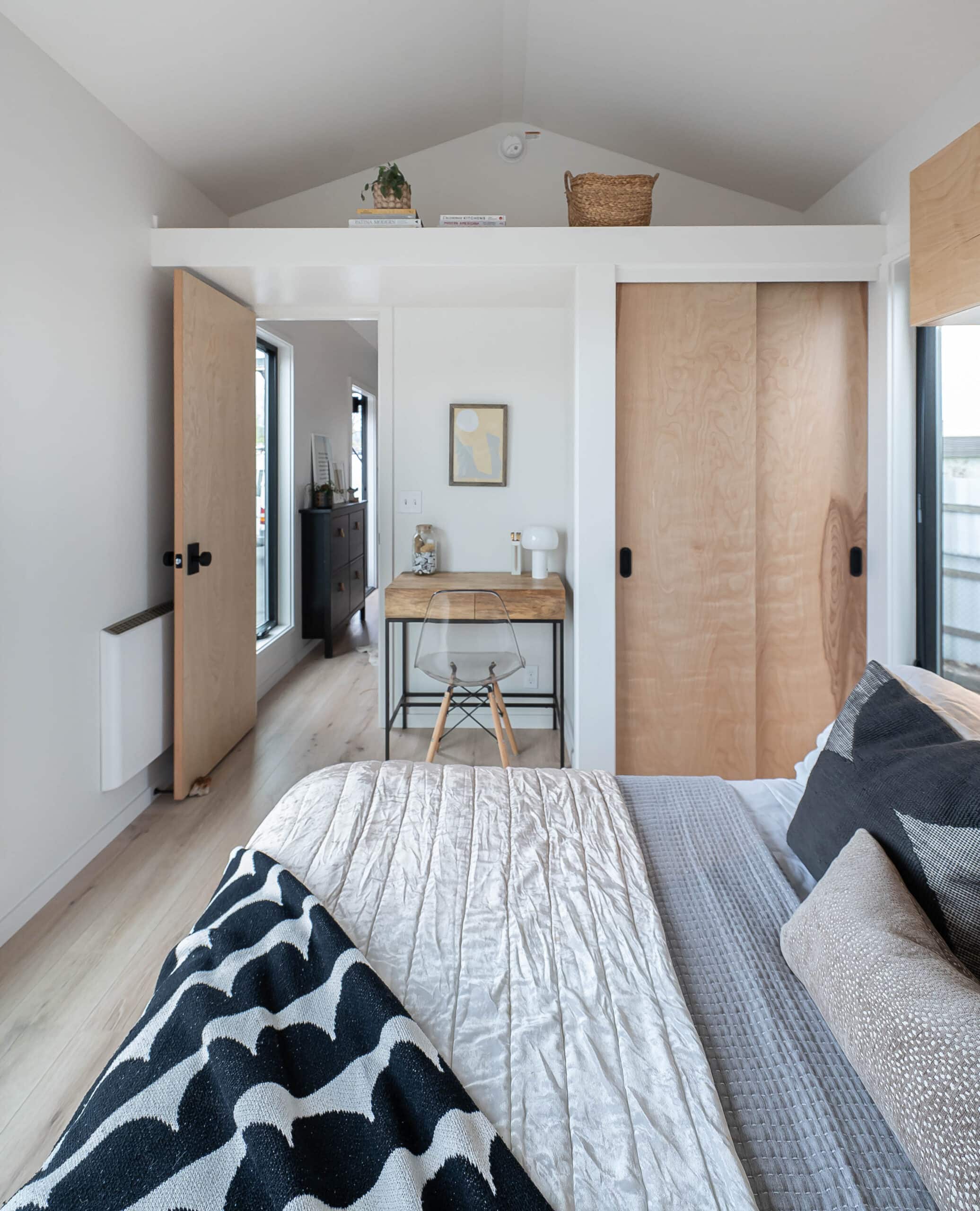 Bedroom showing birch sliding closet doors, desk nook, and hallway in the Urban Gable