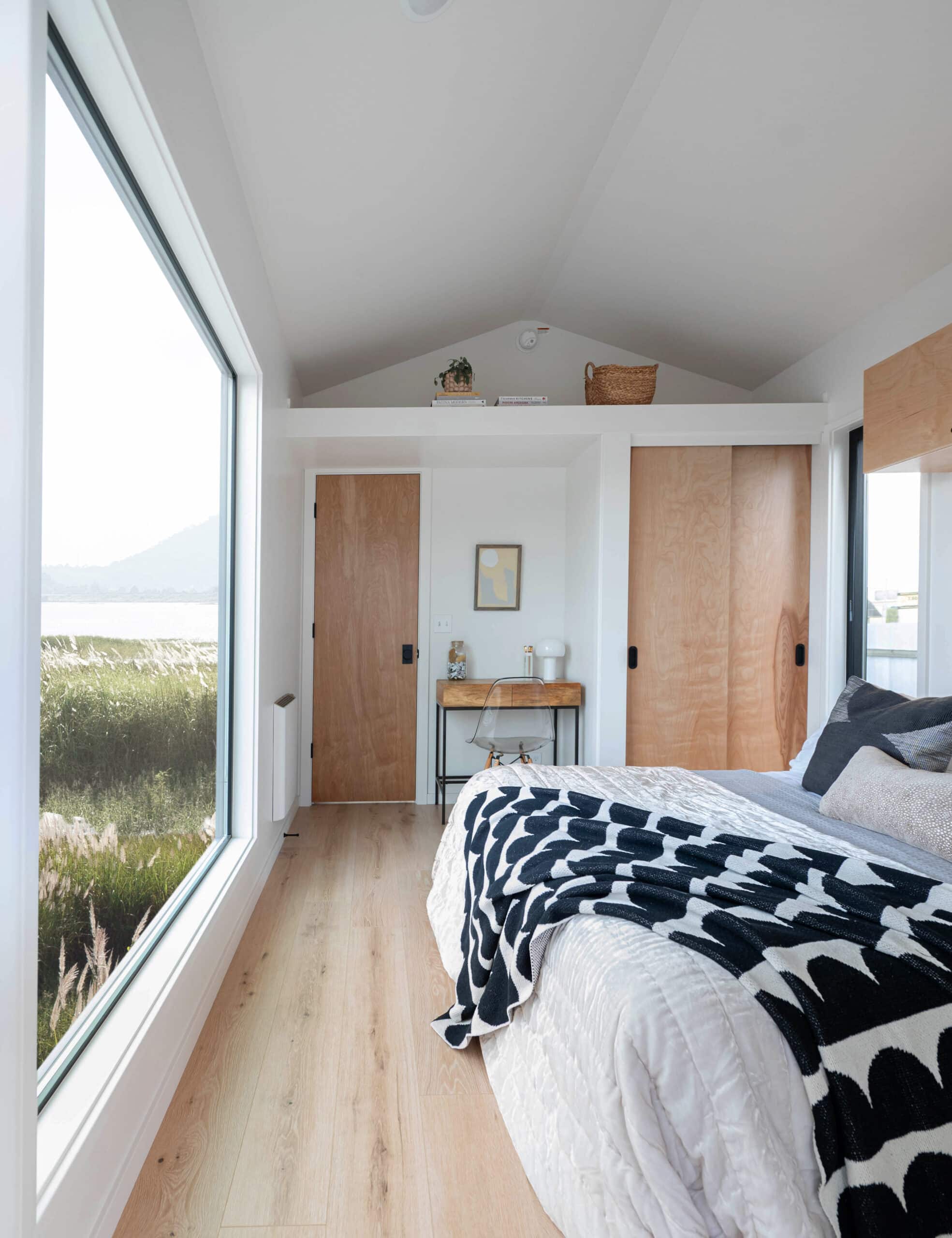Bedroom with floor-to-ceiling window and natural light in the Urban Gable Park tiny house