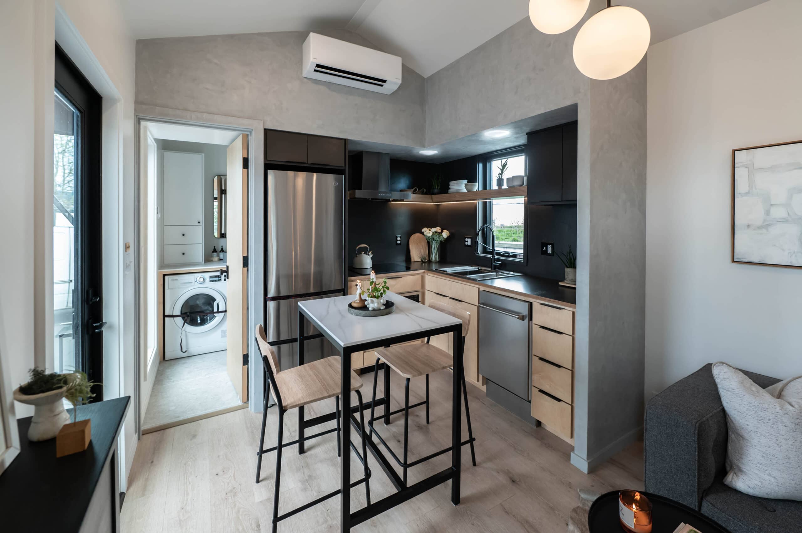 Urban Gable Park kitchen with custom maple cabinetry, graphite countertops, dining bar, and globe lights