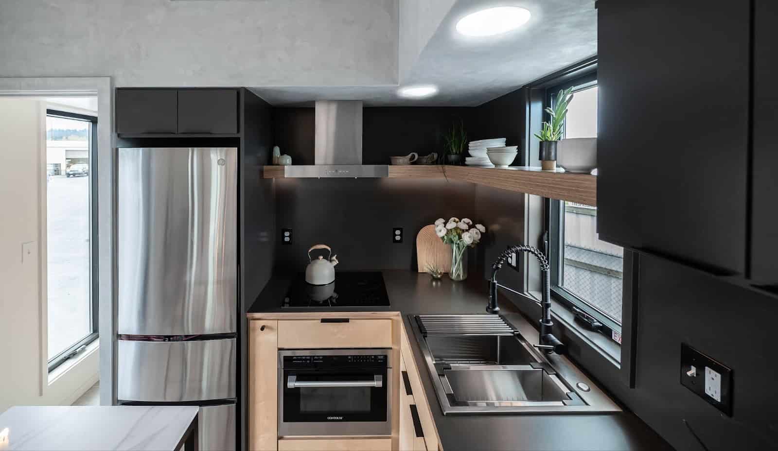 Close-up of the kitchen with floating shelves, under-cabinet lighting, and stainless steel appliances
