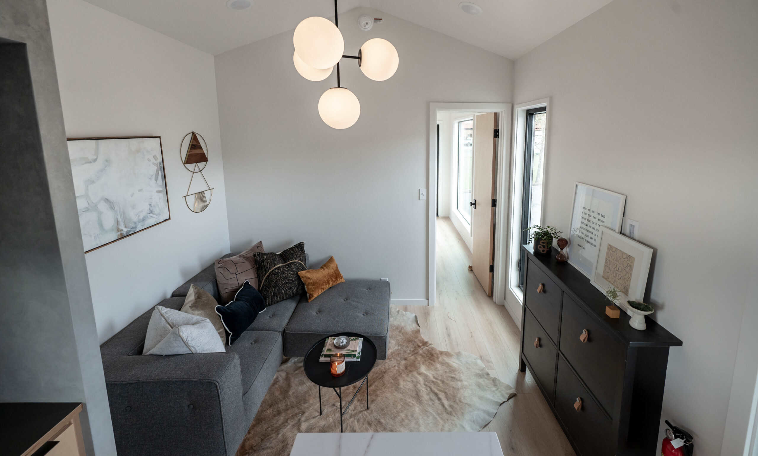 Living room with full sectional sofa, globe chandelier, and drywall ceiling in the Urban Gable Park
