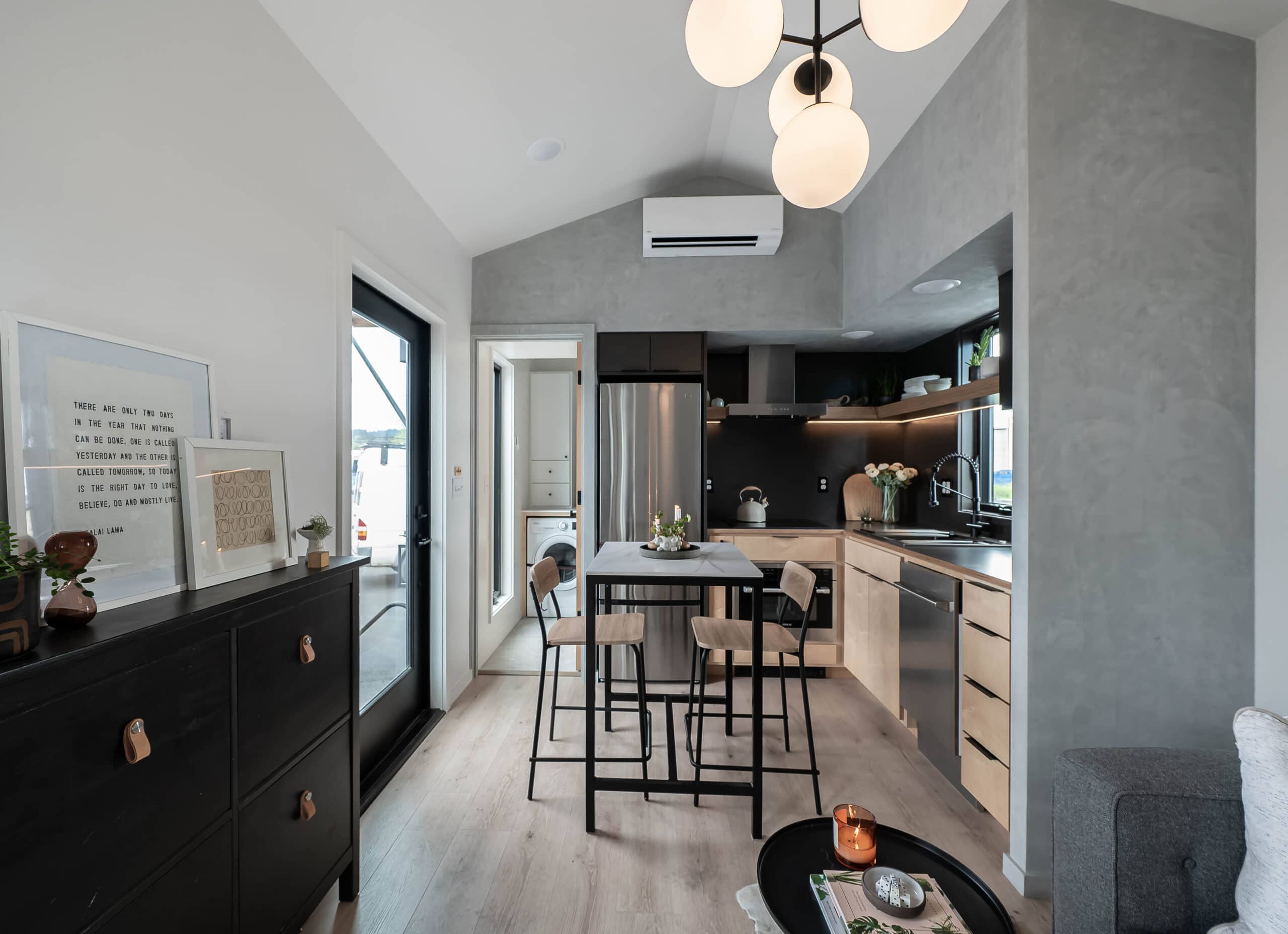 Open-concept view of the Urban Gable Park showing kitchen, globe chandelier, and living area