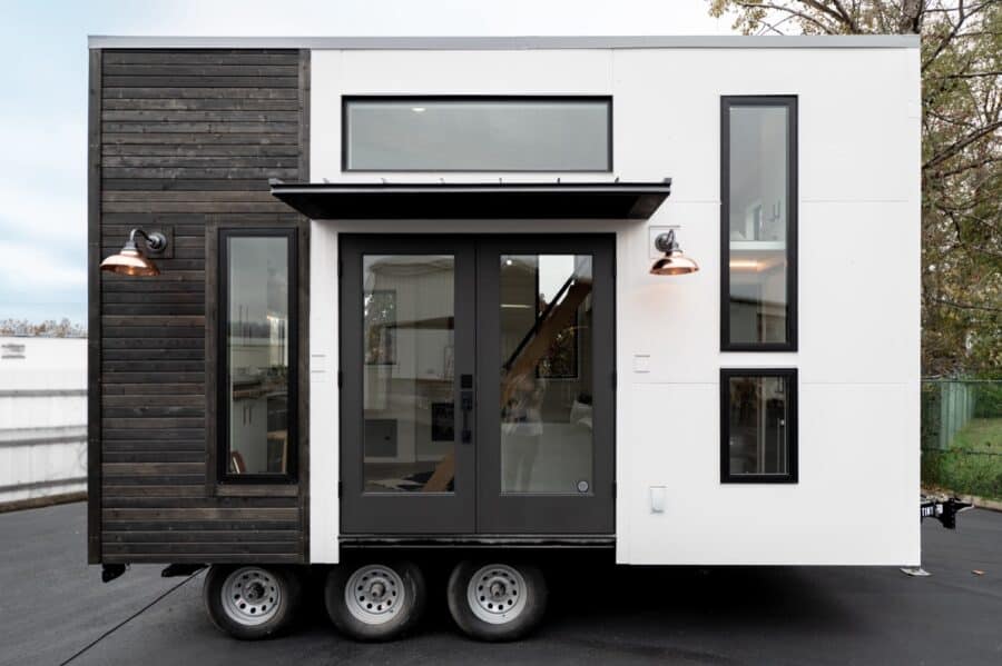 Compact urban tiny house on wheels with sleek black and white exterior.