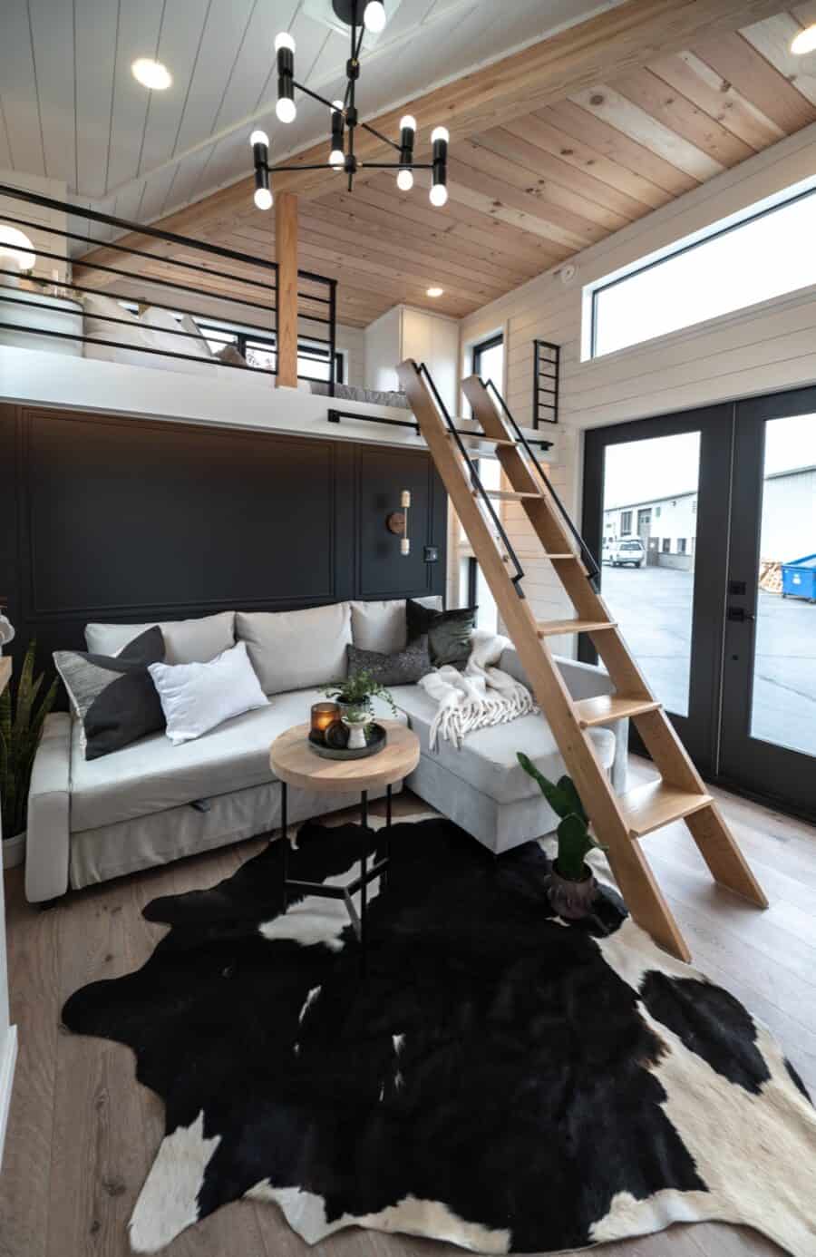 Bright living space in a tiny house with loft and modern decor.