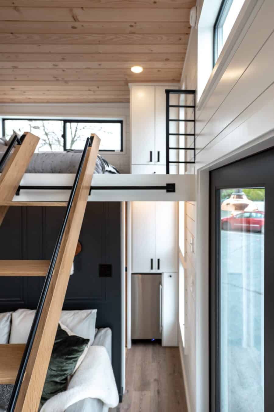 Compact urban tiny house with loft sleeping area and modern design.