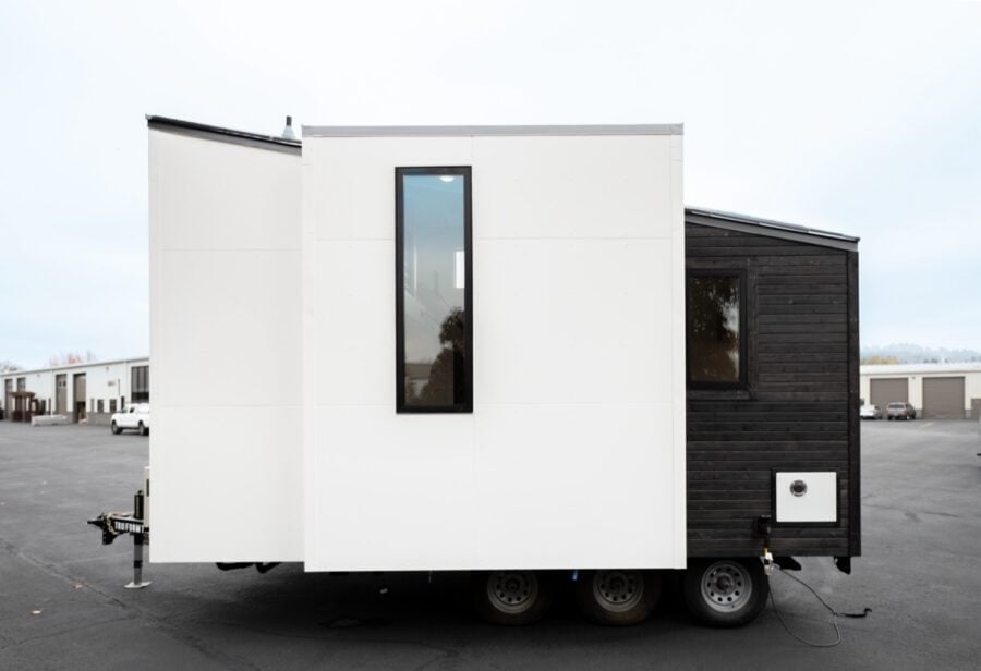 Modern tiny house with sleek white and black exterior, compact and stylish for urban living.