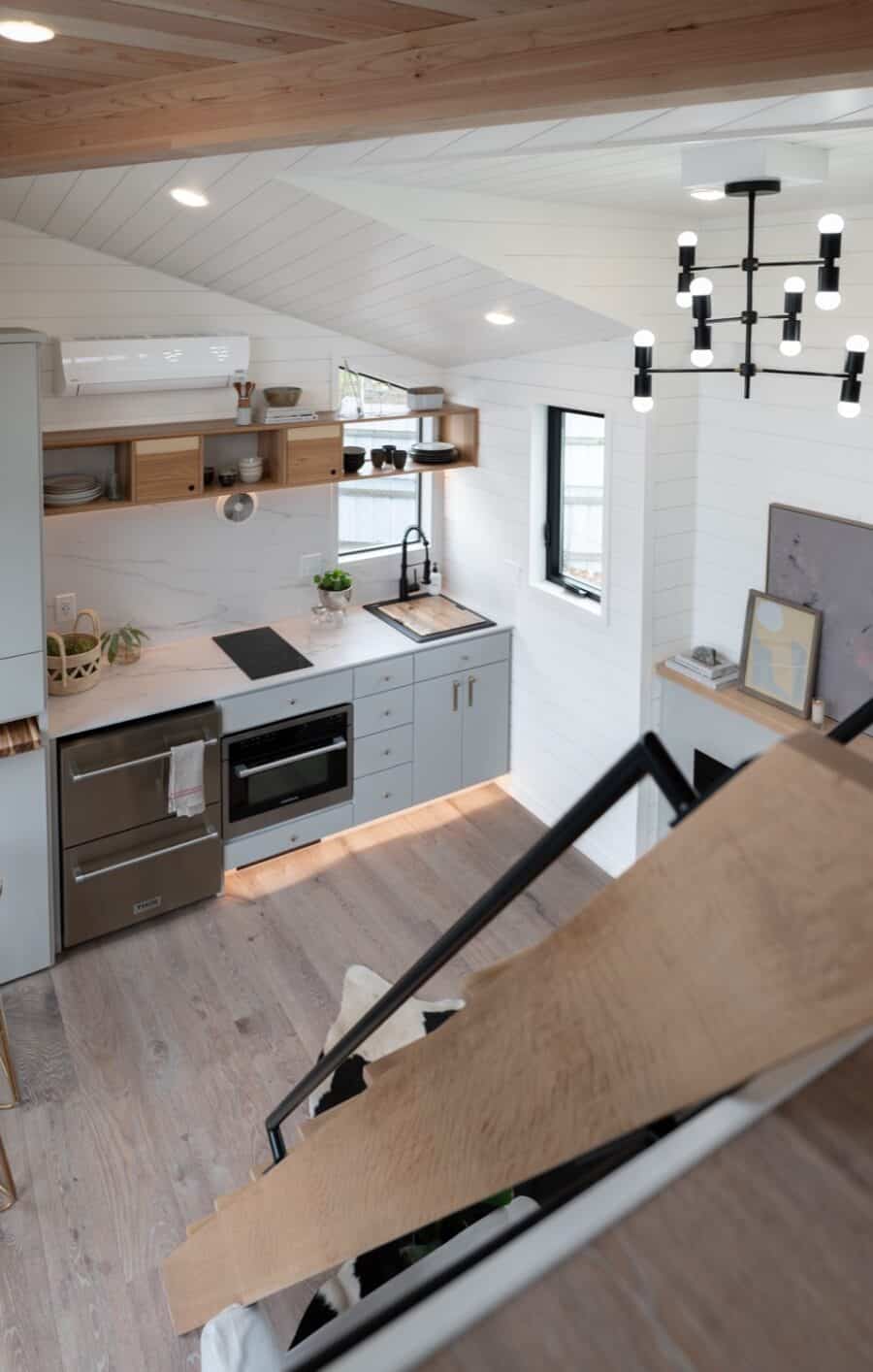 Compact tiny house kitchen with modern appliances and minimalist design.