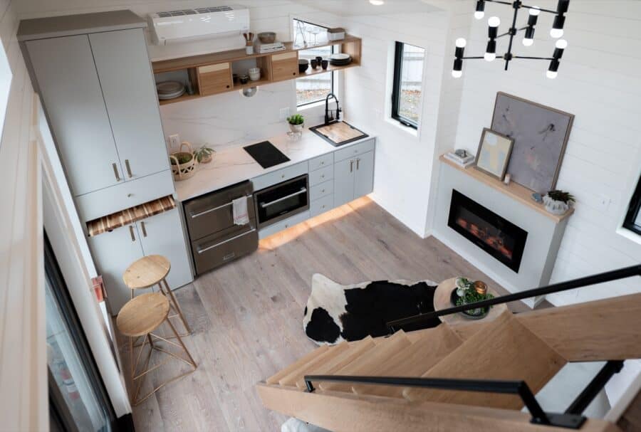 Compact tiny house kitchen with sleek cabinets and modern appliances.