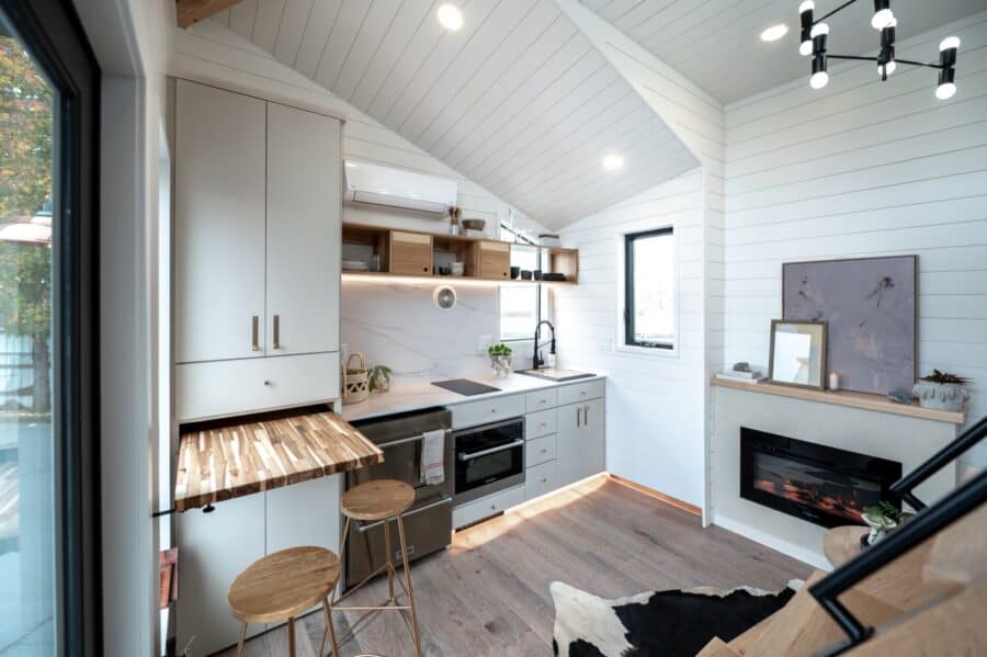 Compact tiny house kitchen with modern appliances and minimalist design.