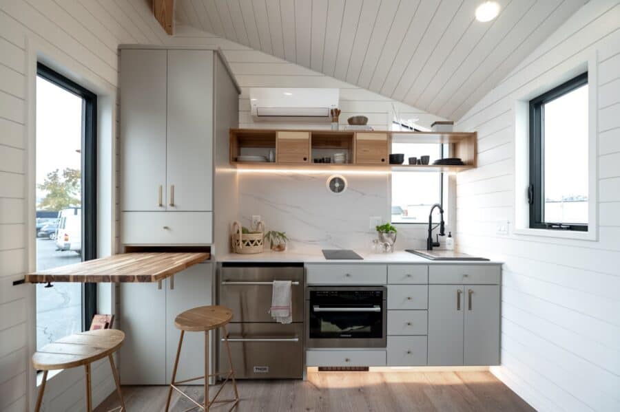 Compact tiny house kitchen with modern appliances and minimalist design.
