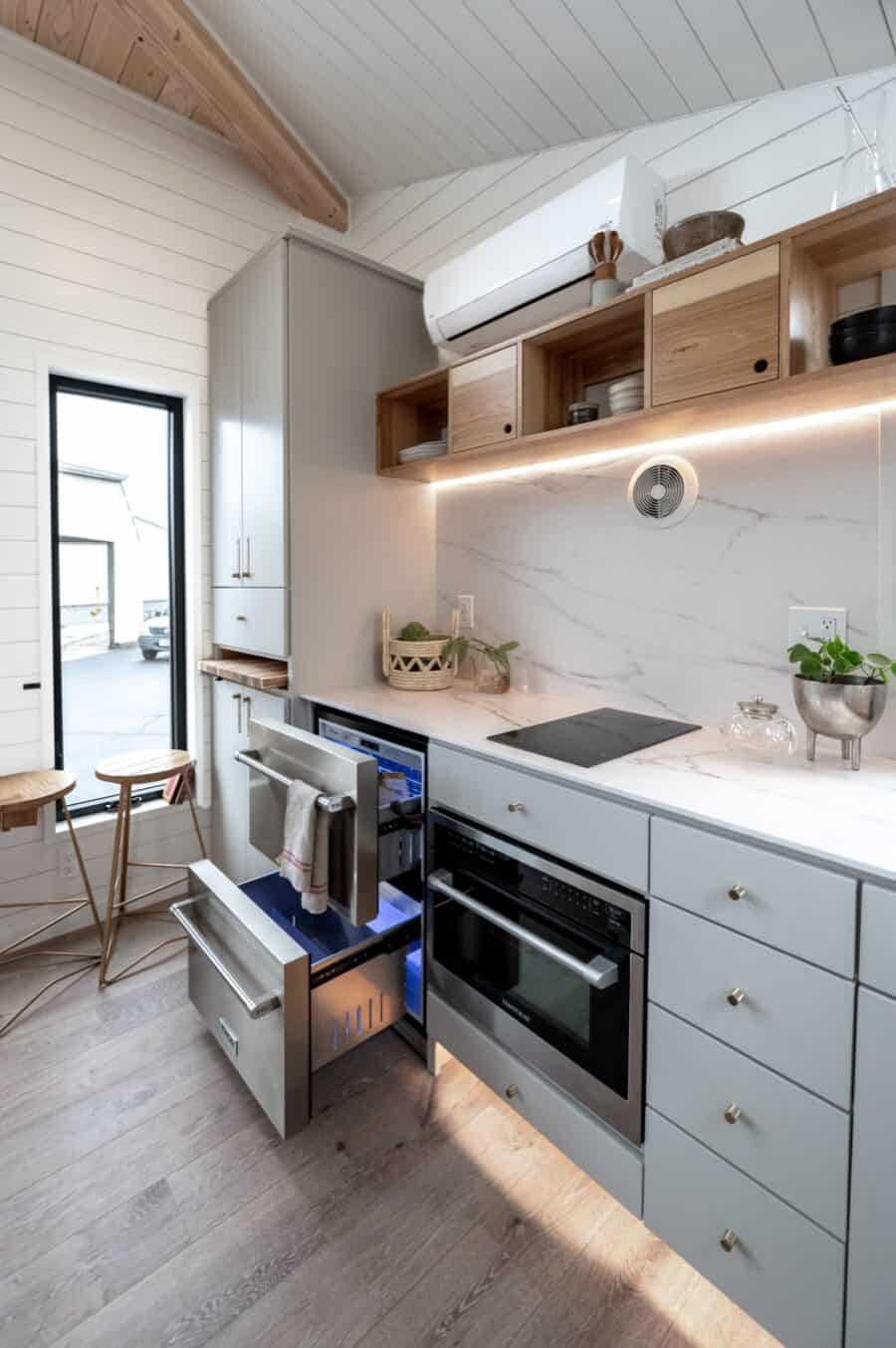 Compact tiny house kitchen with sleek cabinets, smart storage, and modern appliances.